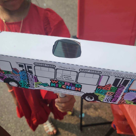 A student shows off a cardboard bus