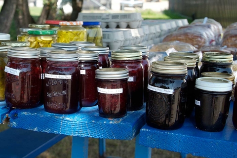 Jars of jam on a table at a market.