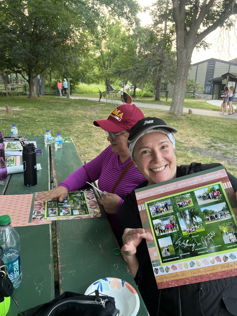 Milena Nunez Garcia smiles and holds a certificate up in a park