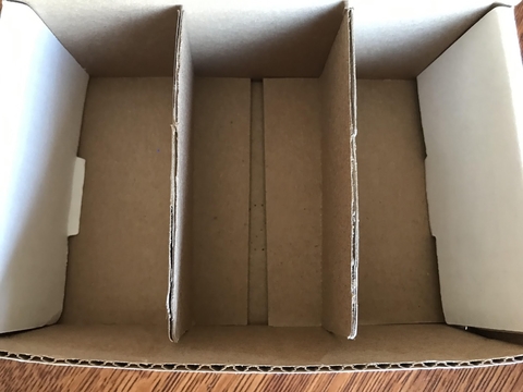 An open cardboard box divided into three sections. 