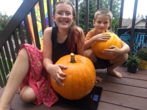 a little boy and a little girl holding pumpkins