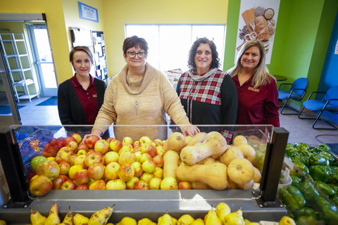 Four women standing behind a produce stand at a food shelf