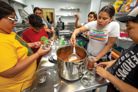 Teens making salsa in a kitchen
