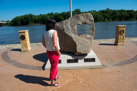 Tourist looking at a memorial plaque on a river