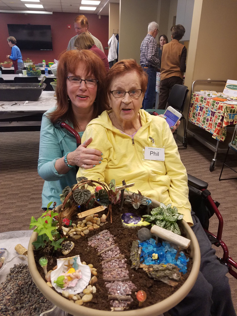 Elderly woman and caretaker with a completed fairy garden