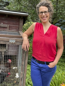 Andi Sutton standing next to a chicken coop.