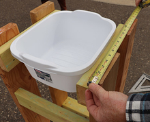 Person using tape measure to determine dimensions for plywood top.