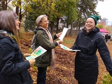 Morgan Bliss with two others handing out flyers near some woods.