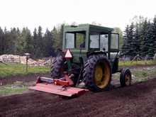 A multivator (machine used for cultivating perennial crops to till hard soil) is being used to prepare strawberry beds for planting.