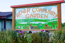 Colorful painted sign in of garden that says Remer Community Garden