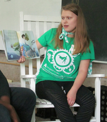 4-H teen reading a picture book aloud.