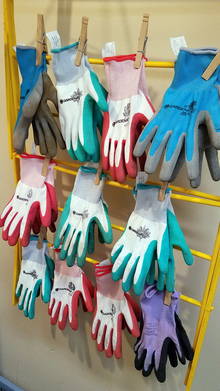 Rack of colored gardening gloves hanging to dry.