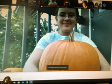 Brita Carlson in Zoom screenshot, holding a pumpkin