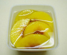 peach slices in syrup in a clear container