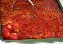strawberries being mashed on a tray