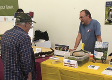 Volunteer talking to fair visitor about invasive species