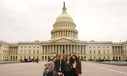 A group of four girls standing in front of the U.S. Capitol building.