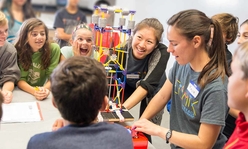 teen teacher with kids and lego model
