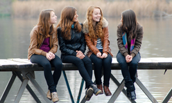 girls sitting on a bridge