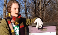 youth holding top of beehive box