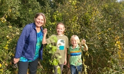 Sherry and two grandkids holding vines outdoors