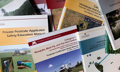 A stack of manuals for pesticide safety categories.