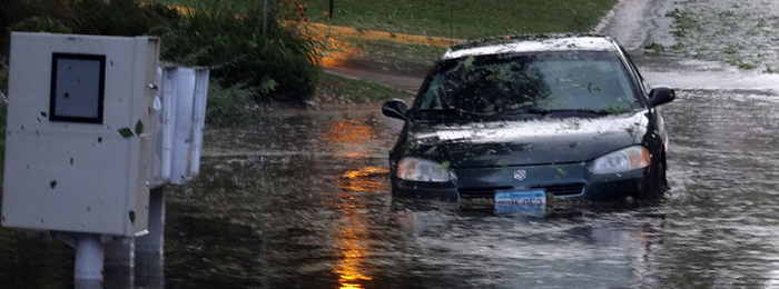 Car driving down a flooded street