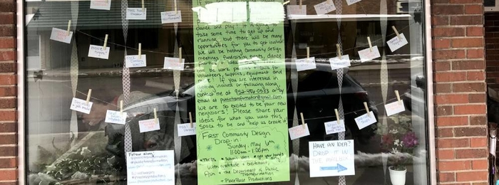 Window front with a sign asking for ideas and clothes pins holding submitted ideas.