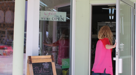 A woman opening a store door