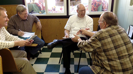 A small team of community leaders meeting with a local business owner at their business.