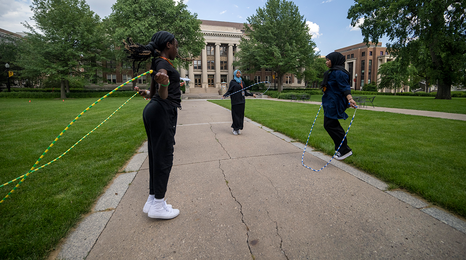 Three girls jump roping while on the University of Minnesota campus.