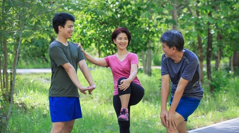 Three family members performing stretches outdoors