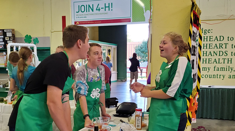 teens in aprons talking at a table
