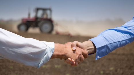 A handshake in a farm field