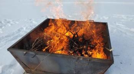Kiln with branches on fire to make biochar