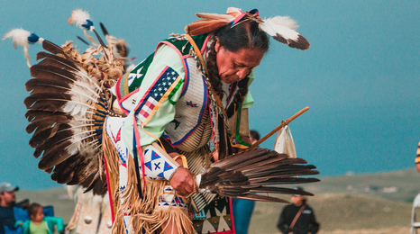 A tribal leader dancing in a powwow
