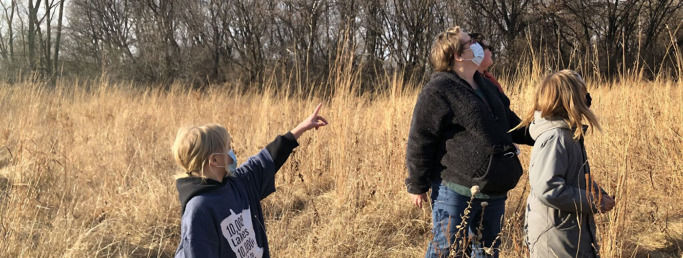 people looking for barn owls in a prairie