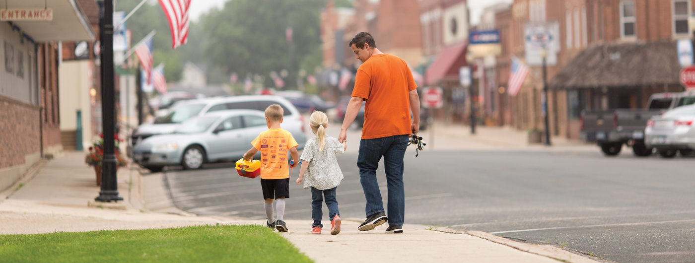 Father and children walking down a street