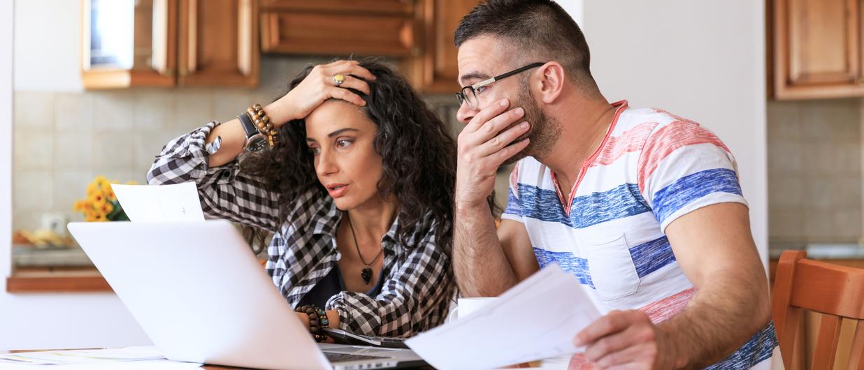 woman and man looking at some paperwork, appearing upset