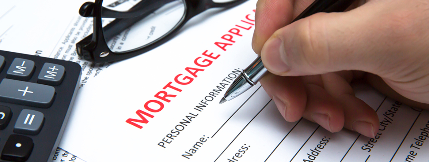 hand completing a mortgage application