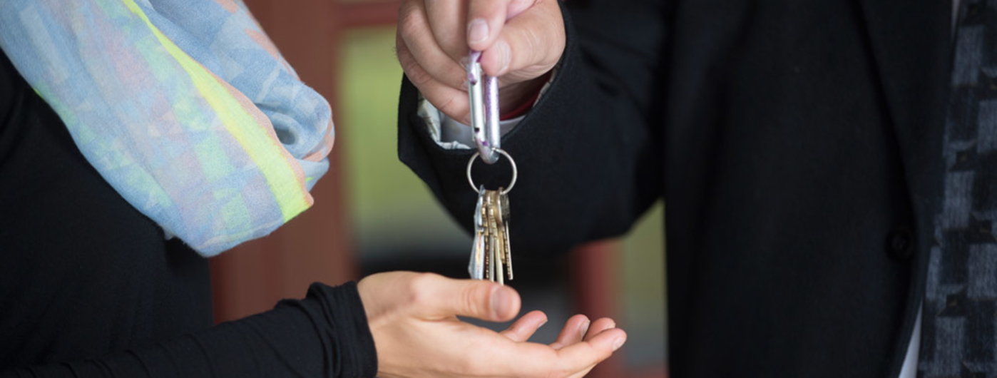Person handing over the keys to their business to a new owner.
