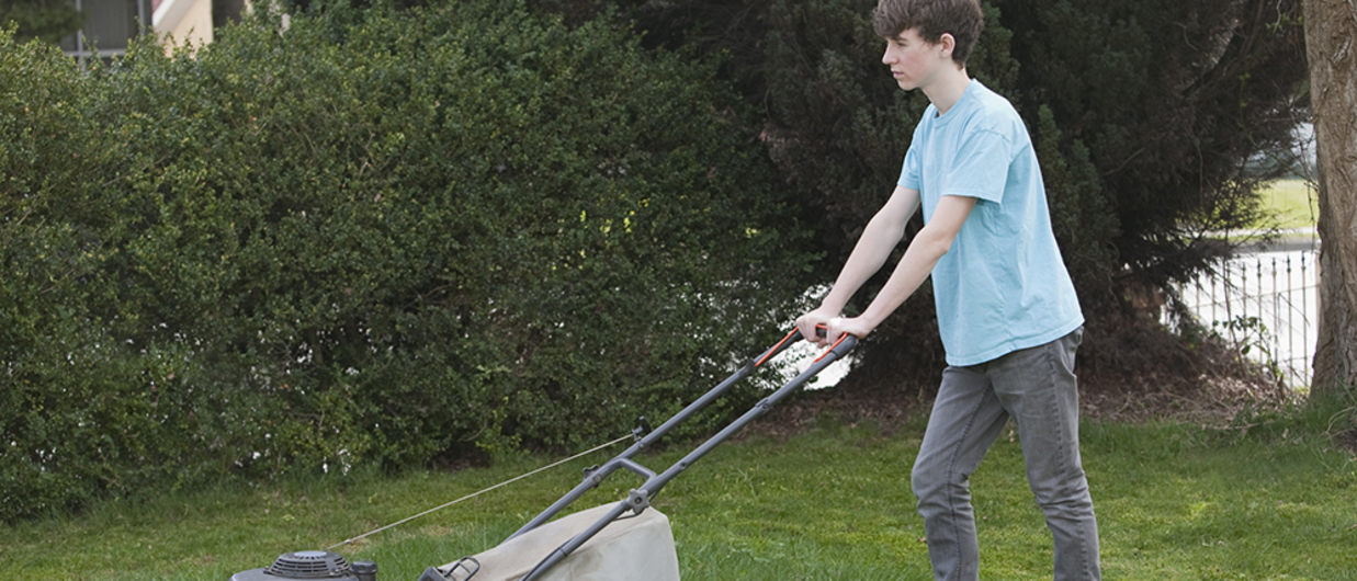Boy pushing lawn mower