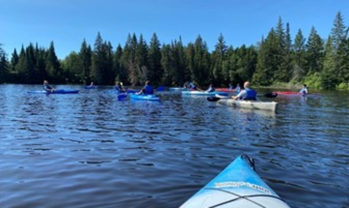 a group of kayakers paddling on a lake