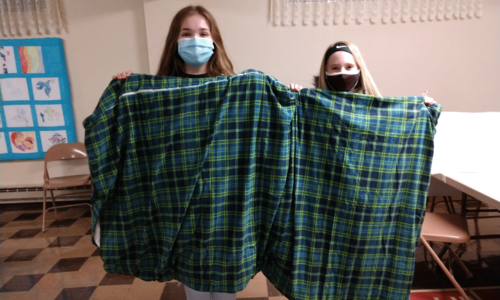 2 kids holding up a weighted blanket they made.