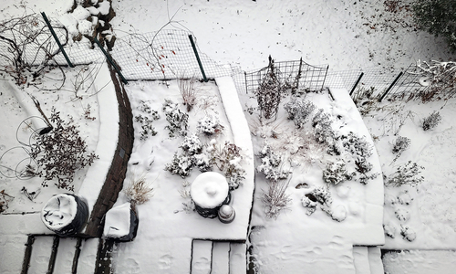 Aerial view of a terraced garden covered in snow.