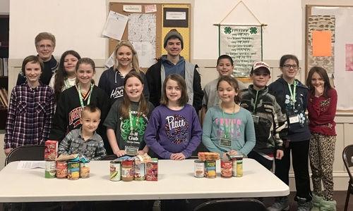 Northern Lights 4-H Club and vittles with canned goods on the table.