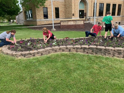 Youth members planting flowers in landscape planter