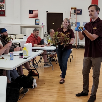 Noah and Julie teach plant propagation in a room with an American flag
