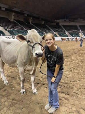4-H'er Alison F. posing for photo with heifer