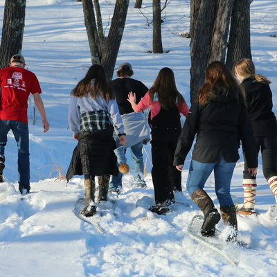 Teens snowshoeing in the woods